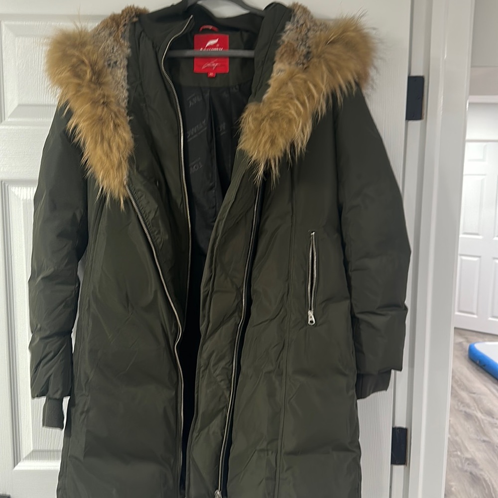 Green warm women’s zip up winter jacket with rabbit fur hood.